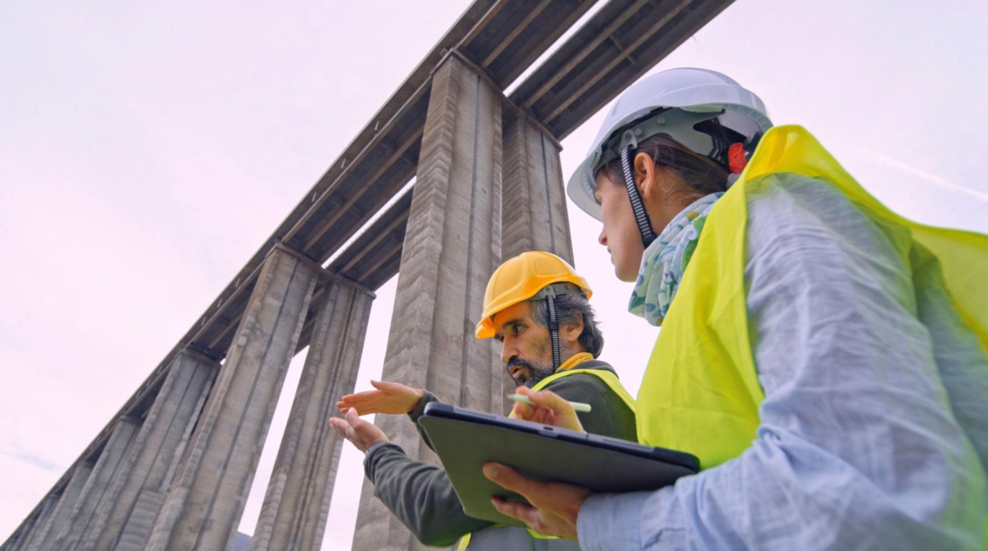 Crew reviewing layout under concrete bridge columns